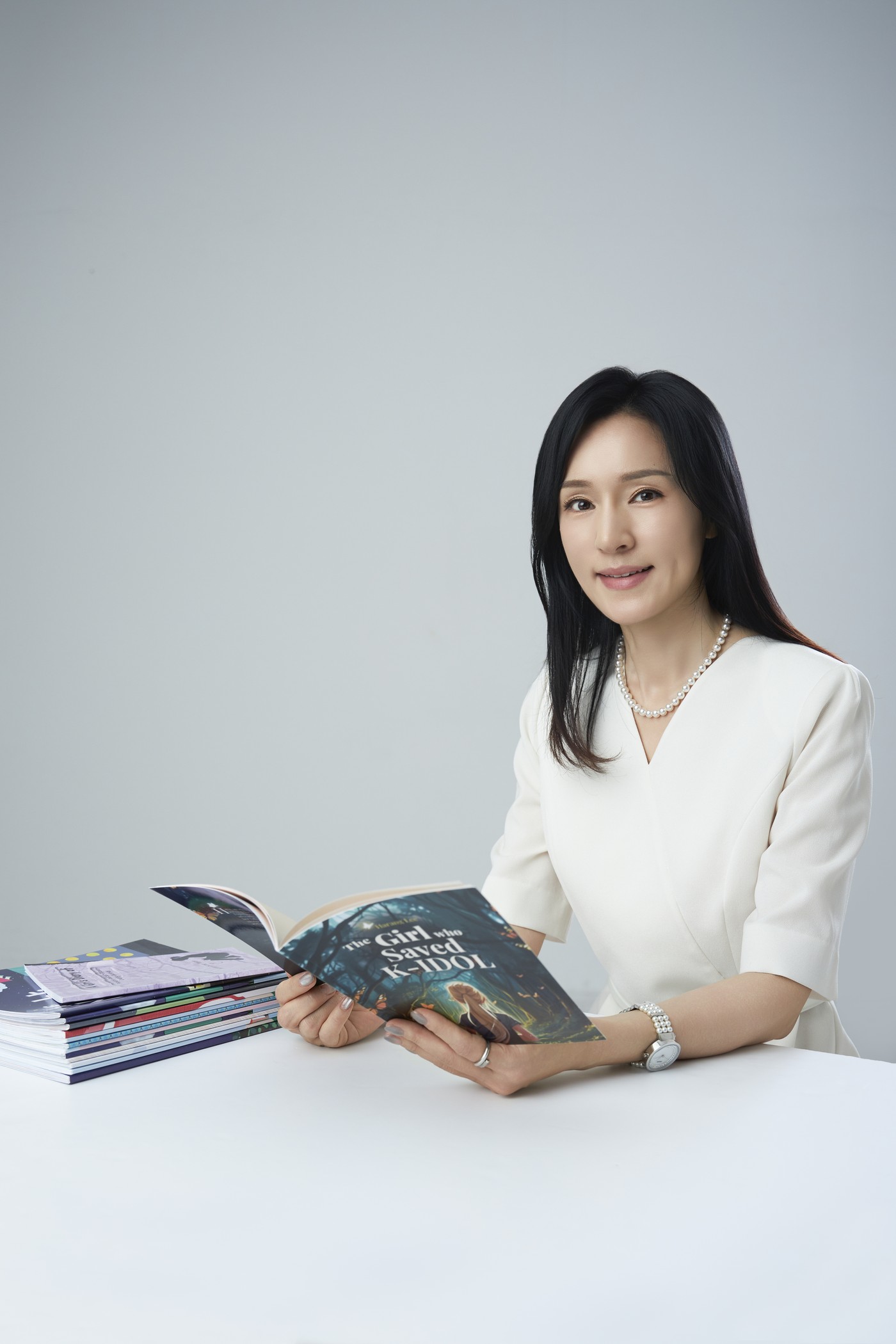 영어책을 펼쳐 들고 있는 홍희경 원장